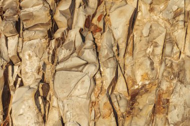 Doğal taş dokusuna yakın. Soyut doğa kaya arka planı. Sarı-turuncu keskin taş levhalar.