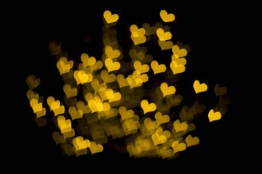 Kalp şeklinde soyut, bulanık, sarı ışıklar. Odaklanamayan sokak festivali aydınlatması. Sevgililer Günü, düğün, aşk geçmişi