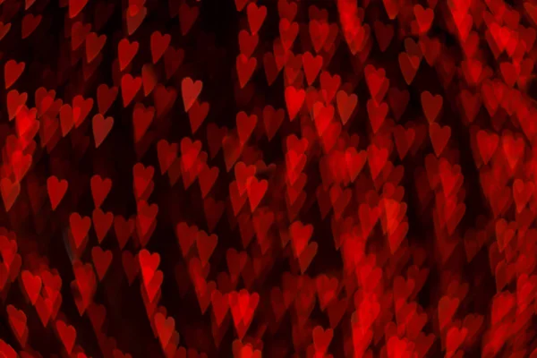 Walentynki tło z rozmytych czerwonych świateł w kształcie kreatywnych serc na czarno. Bokeh światło. Zamazane świąteczne dekoracje uliczne. — Zdjęcie stockowe
