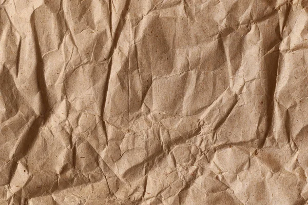 ラフな折り目と曲がりを持つ茶色の砕いた包装紙の一部を閉じます 要旨現代の流行紙のテクスチャ背景 — ストック写真