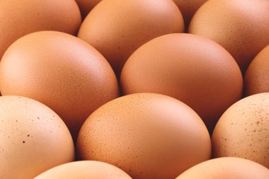 Derin bir tarla derinliği olan taze kahverengi tavuk yumurtalarını kapatın. Soyut modaya uygun yiyecek rustik doku arka planı