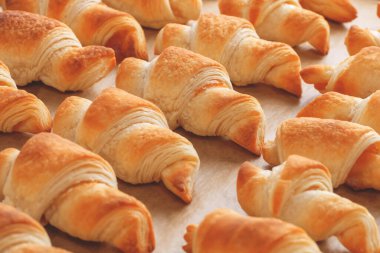 Taze pişmiş poğaça kruvasan reçelli ve kabartma kağıdının üzerinde sığ bir tarla derinliği var..