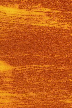 Dikey odaklı, fırça darbeleri izleri olan paslı bir metal levha. Soyut modern lekeli kırmızı paslı doku arkaplanı