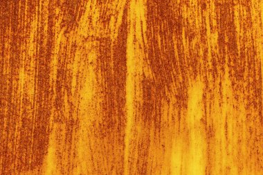 Eski, paslı bir metal levhanın yüzeyinde fırça darbeleri izleri var. Soyut trend sarı kırmızı paslı doku arkaplanı