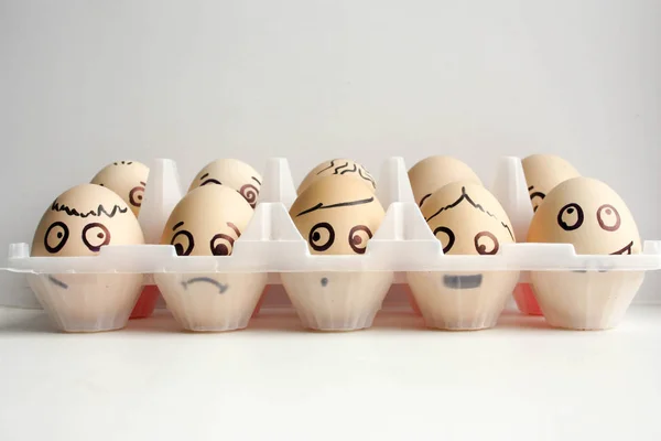 Eieren met een geschilderde gezicht in twee rijen — Stockfoto