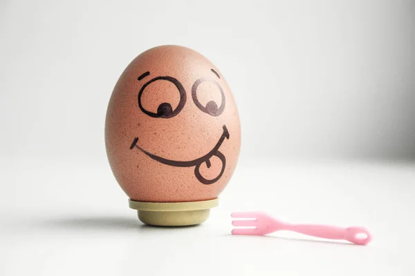 Diet concept. A fork and an egg with a painted — Stock Photo, Image