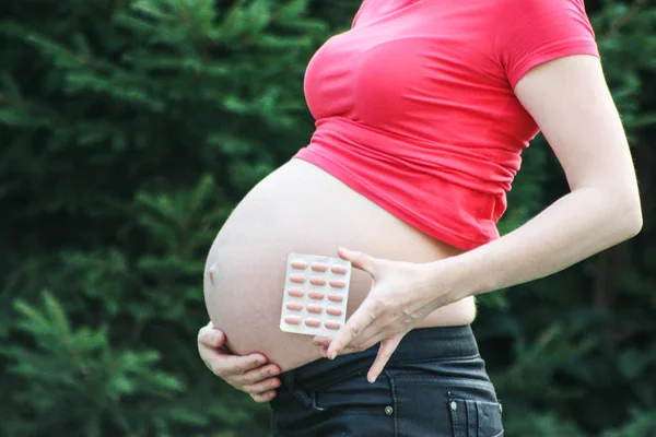 Zwangerschaps concept. Meisje in rood op een natuur — Stockfoto