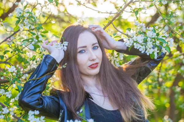 Modelo bonito posando em um fundo de uma árvore florescendo. — Fotografia de Stock