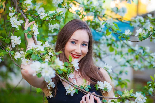 Beautiful girl in a long skirt among a blossoming apple — Stock Photo, Image