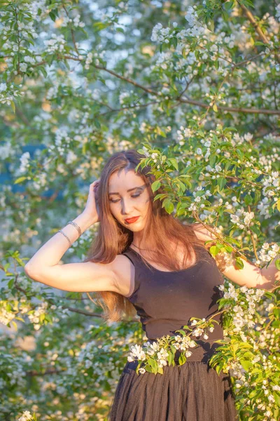 Çiçek açan elmanın arasında uzun etekli güzel bir kız. — Stok fotoğraf