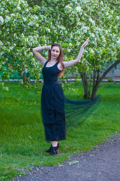 Menina bonita em uma saia longa entre uma flor — Fotografia de Stock