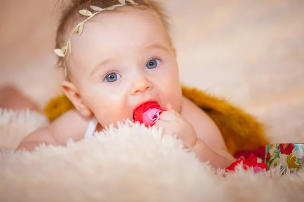 Küçük bebek, güller içinde bir melek bej üzerinde — Stok fotoğraf
