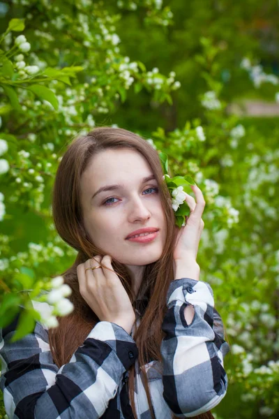 Vacker flicka i ett blommande äpple — Stockfoto