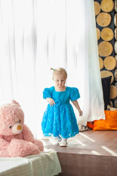 Uma criança em um vestido azul corre para a frente alegremente. Infância — Fotografia de Stock