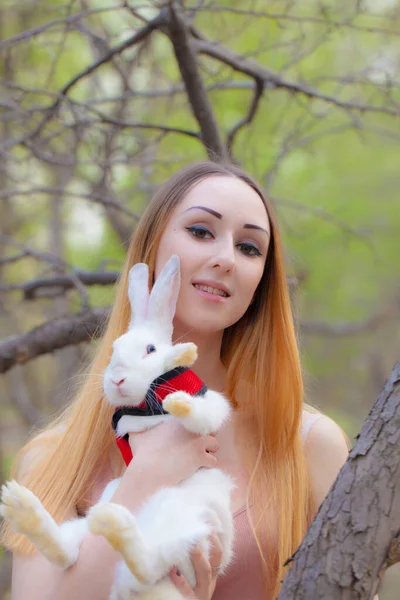 Menina atraente com um coelho branco e fabuloso. caminhar e — Fotografia de Stock