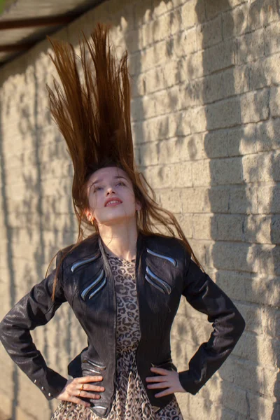 Menina com cabelo longo bonito. Beleza de cabelos escuros em um couro — Fotografia de Stock