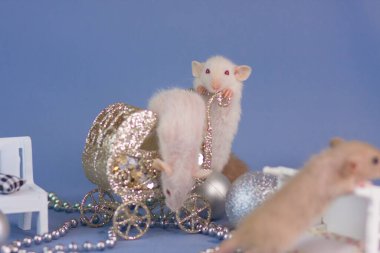 Mavi arka planda gümüş oyuncakları olan fare. Tahta beyaz bir beşik ile