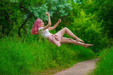 Merhaba Spring! Geyik ve çiçeklerin arasında ahududu saçlı güzel bir kız. Bahar rüyası. Kız uçuyor. Yükselme ve ağırlıksızlık