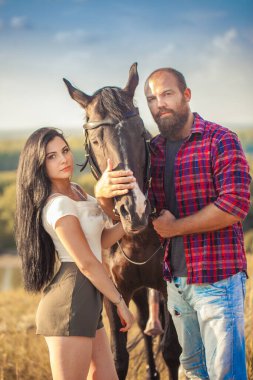 Esmer kız ve siyah atlı sakallı vahşi adam. Seksi bir çift. Yaz gezisi. Aşk hikayesi.