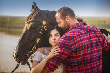 Esmer kız ve siyah atlı sakallı vahşi adam. Seksi bir çift. Yaz gezisi. Aşk hikayesi.