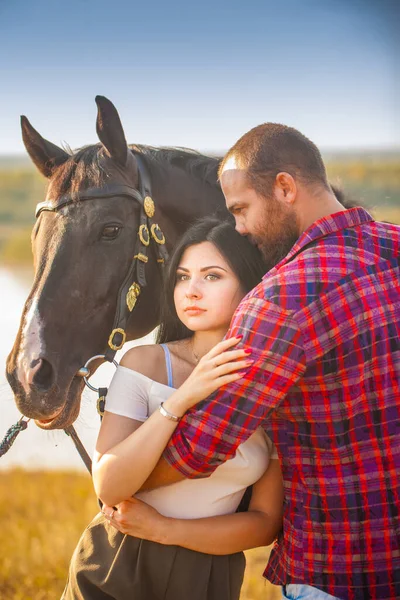 Brunett Tjej Och Brutal Kille Med Skägg Med Svart Häst — Stockfoto