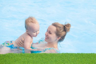 Anne ve bebek havuzda dinleniyor.