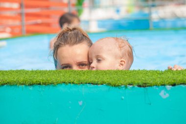 Anne ve bebek havuzda dinleniyor.