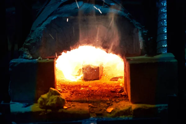 Der Ofen eines Schmiedes. Glühendes rotes Metall. Flammen schlagen aus dem Ofen. — Stockfoto