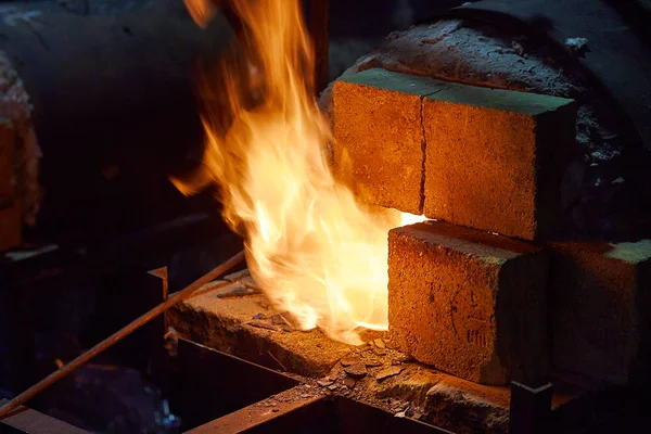 Der Ofen eines Schmiedes. Glühendes rotes Metall. Flammen schlagen aus dem Ofen. — Stockfoto