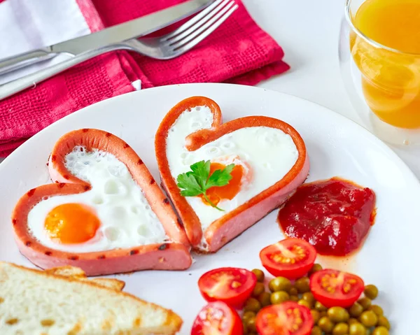 Heart shaped sausages with fried eggs — Stock Photo, Image