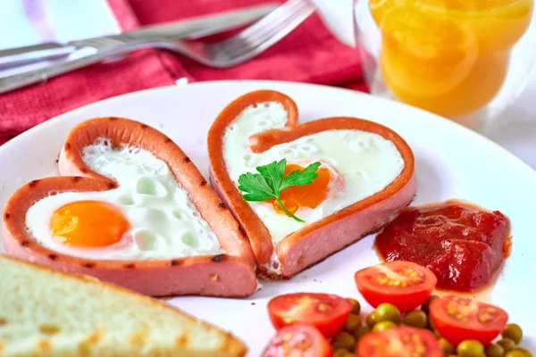 Heart shaped sausages with fried eggs — Stock Photo, Image