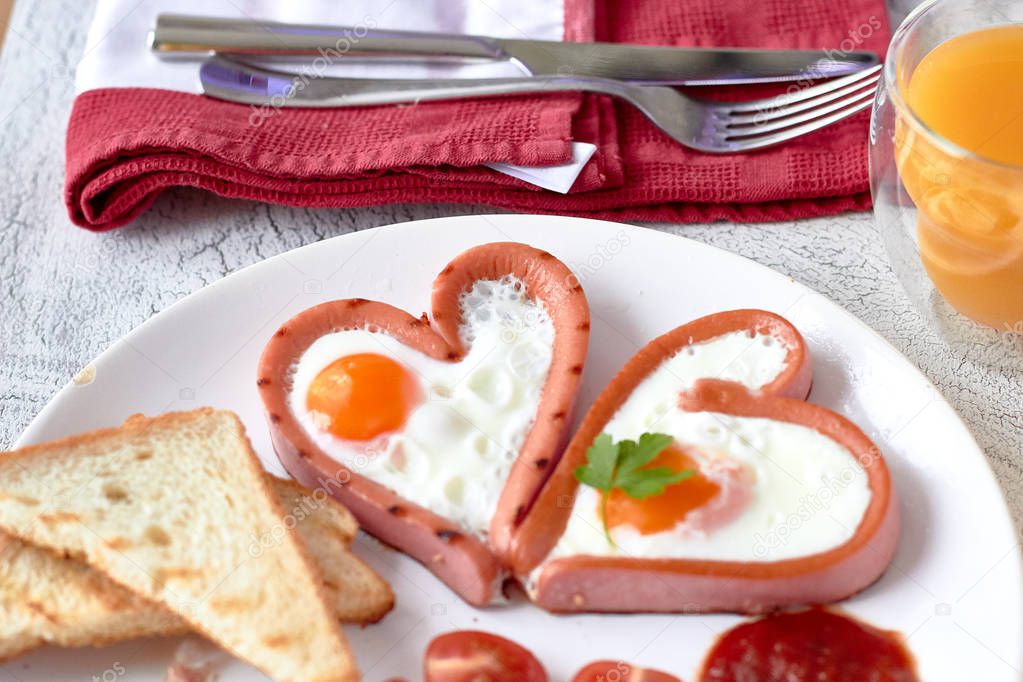 Heart shaped sausages with fried eggs