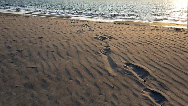 바다에 이르는 모래에 발자국 — 스톡 사진