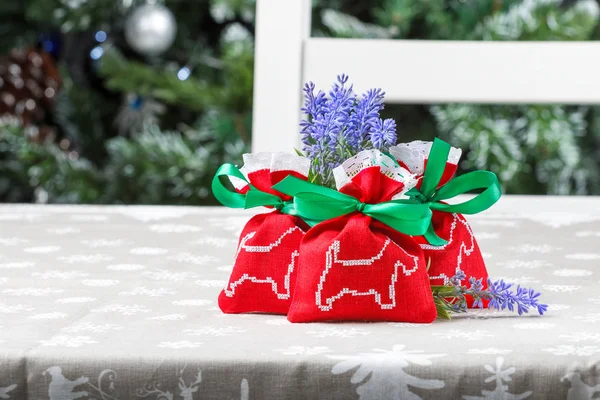 A picture of a dog on the red bags, blue flowers. The background tree. — Stock Photo, Image