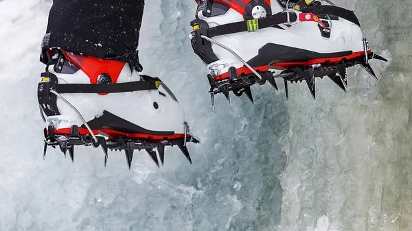 Crampons close-up em seus pés escalador de gelo, alpinista em uma cachoeira congelada — Fotografia de Stock