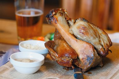 Soslar ve bira ile bir tahta üzerinde domuz knuckle