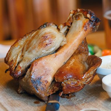 Soslar ve bira ile bir tahta üzerinde domuz knuckle