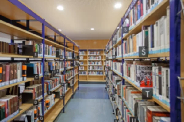 Bastidores de libros en la biblioteca. Fondo desenfocado . — Foto de Stock