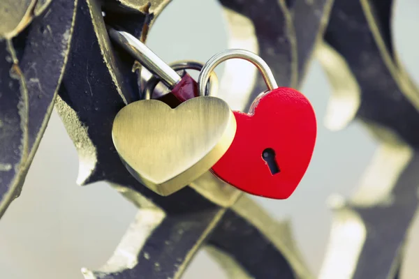 Två lås i form av ett hjärta hängande. — Stockfoto