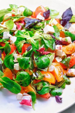 Taze sebze salatası. Kırmızı ve sarı domates, fesleğen, keçi peyniri. Konsept: sağlıklı gıda.