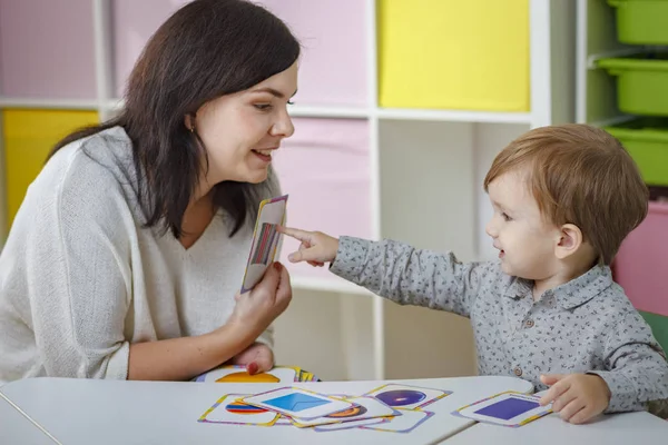 Anne ya da öğretmen resmi gösteren çocuk öğretir