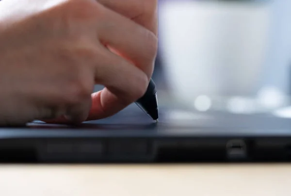 Graphic designer at work. The designer draws a graphic pen on the tablet. Close-up, blurred background — Stock Photo, Image