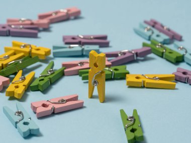 Renkli ahşap mandallar alışılmadık bir şekilde mavi arka planda serilmiştir.