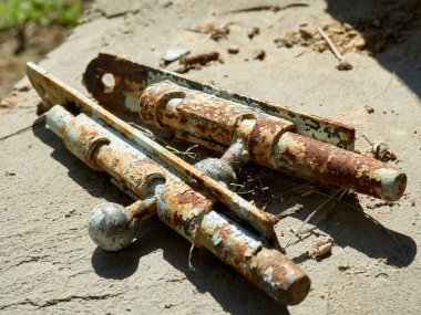 Beton zeminde paslı metal mandal.