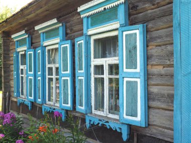 Bir Rus köyünde mavi panjurlu eski bir evin manzarası. Rusya 'daki eski binalar