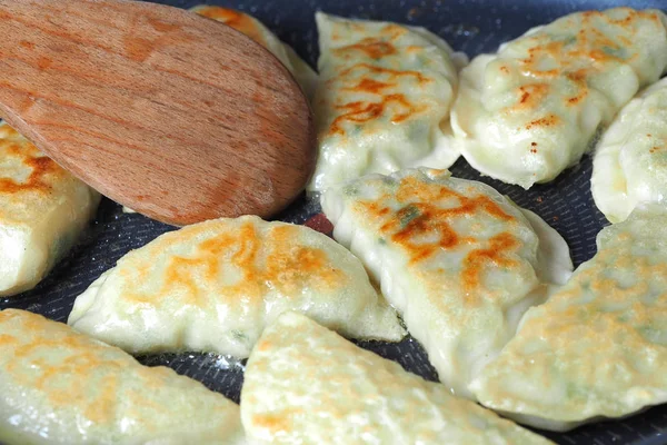 Knedlíky jsou smažené na pánvi. Asijské jídlo s různými náplněmi. Smažená gyoza — Stock fotografie