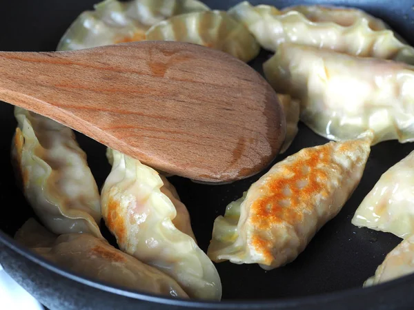 Knödel werden in der Pfanne gebraten. asiatisches Gericht mit einer Vielzahl von Füllungen. gebratener Gyoza — Stockfoto