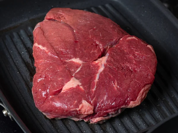 Un jugoso trozo de carne cruda se encuentra en la sartén. Comida antes de cocinar. La vista desde arriba . —  Fotos de Stock