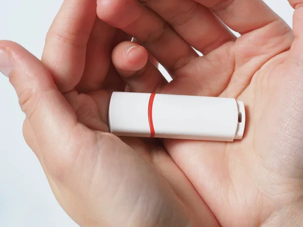 Blanco unidad flash USB aislado con franja roja en las manos de cerca — Foto de Stock