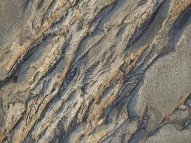 Sabah dalgalarla yıkanan koyu kayanın dokusu